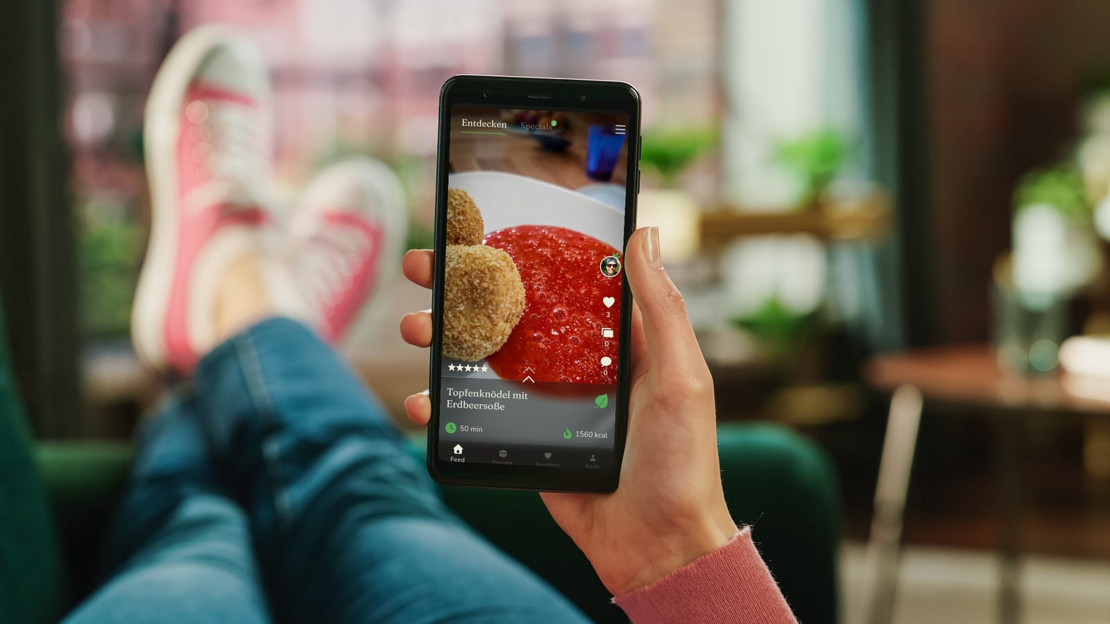 Jemand liegt entspannt auf dem Sofa und stöbert im Rezept-Feed der Royal-Food-Club-App